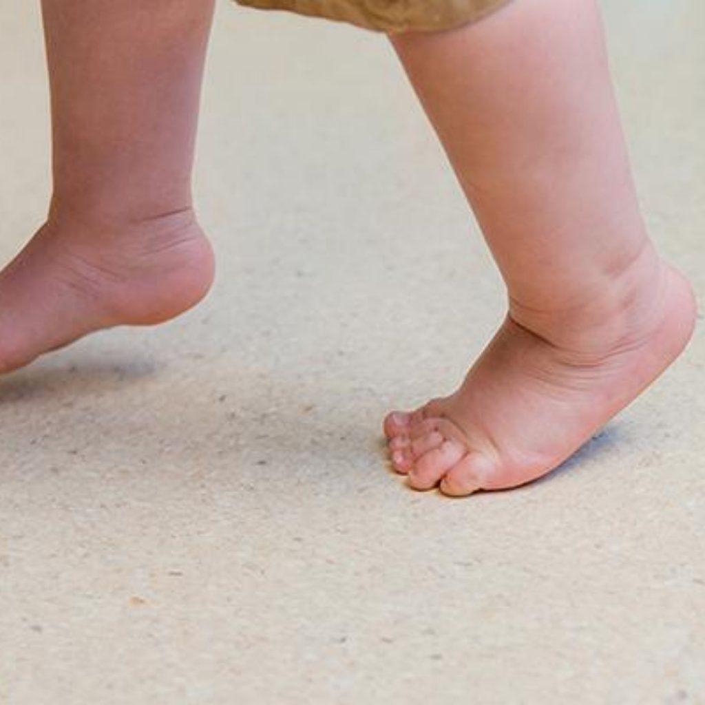 Infant walking store on tiptoes